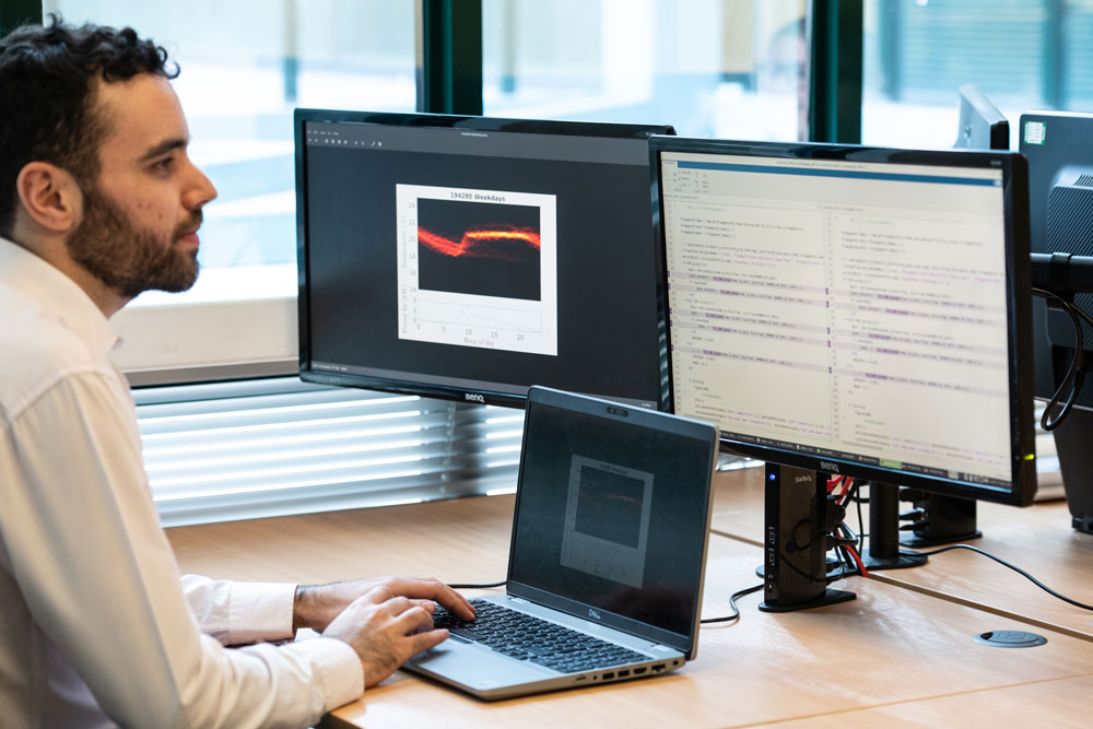 Man looking at weekly energy data on computer screens